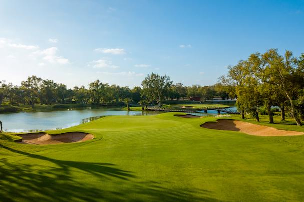 A resort golf course in Morocco with palm trees and the landscape beyond on a clear day