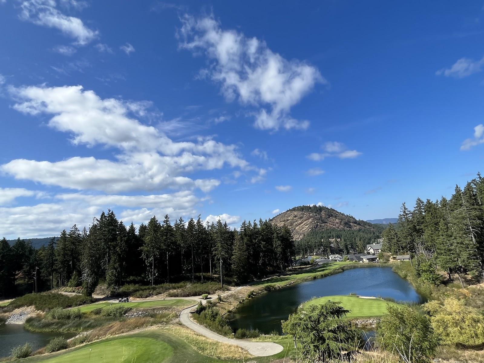 Bear Mountain Mountain Course near Victoria, a mountaintop fairway with rock outcrops and forest looking toward distant peaks, Vancouver Island, British Columbia, Canada