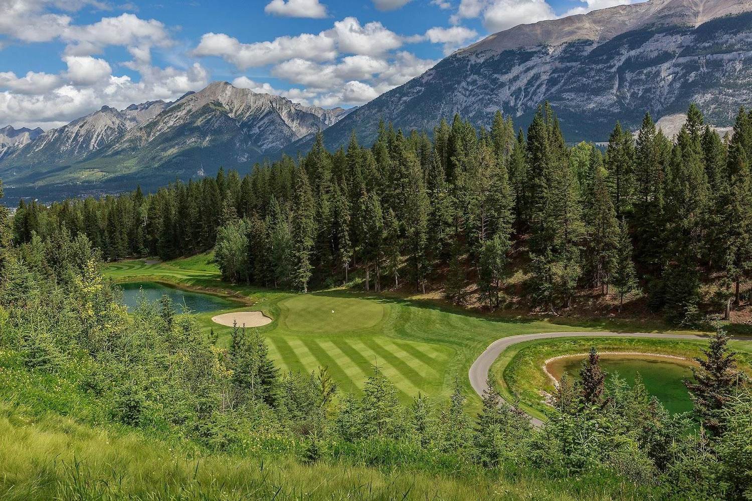 Stewart Creek Golf Club in Canmore, a mountain fairway beneath the Three Sisters peaks of the Canadian Rockies, Alberta, Canada