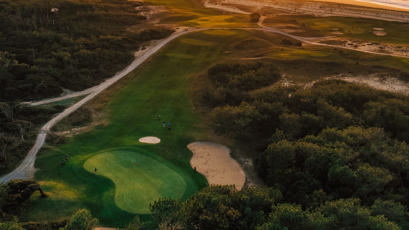 Golf de Moliets, fairway running through tall pines toward the Atlantic dunes on the Landes coast of southwest France