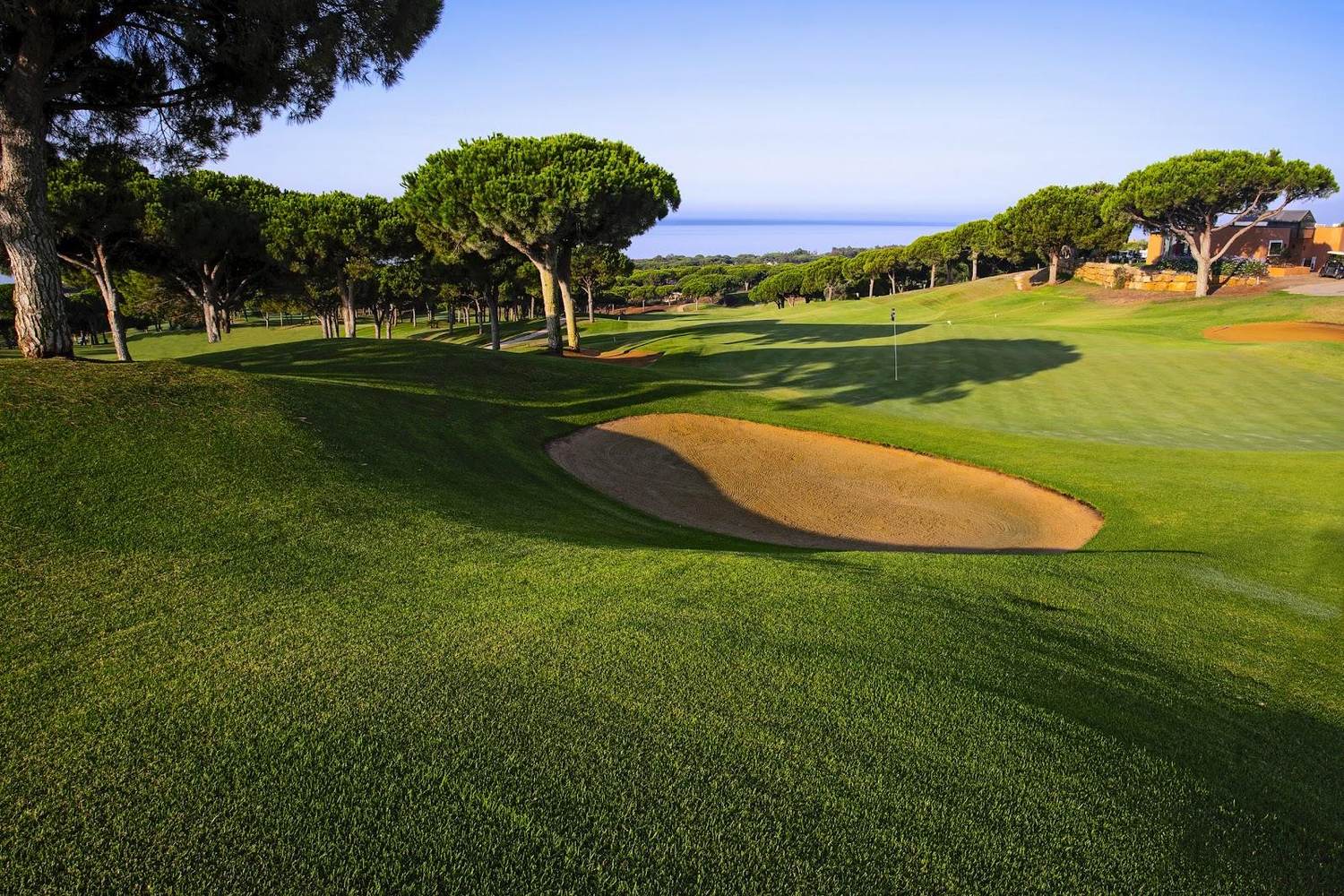 Cabopino Golf Marbella, hilly fairway above the dunes and marina on the eastern edge of Marbella, Spain
