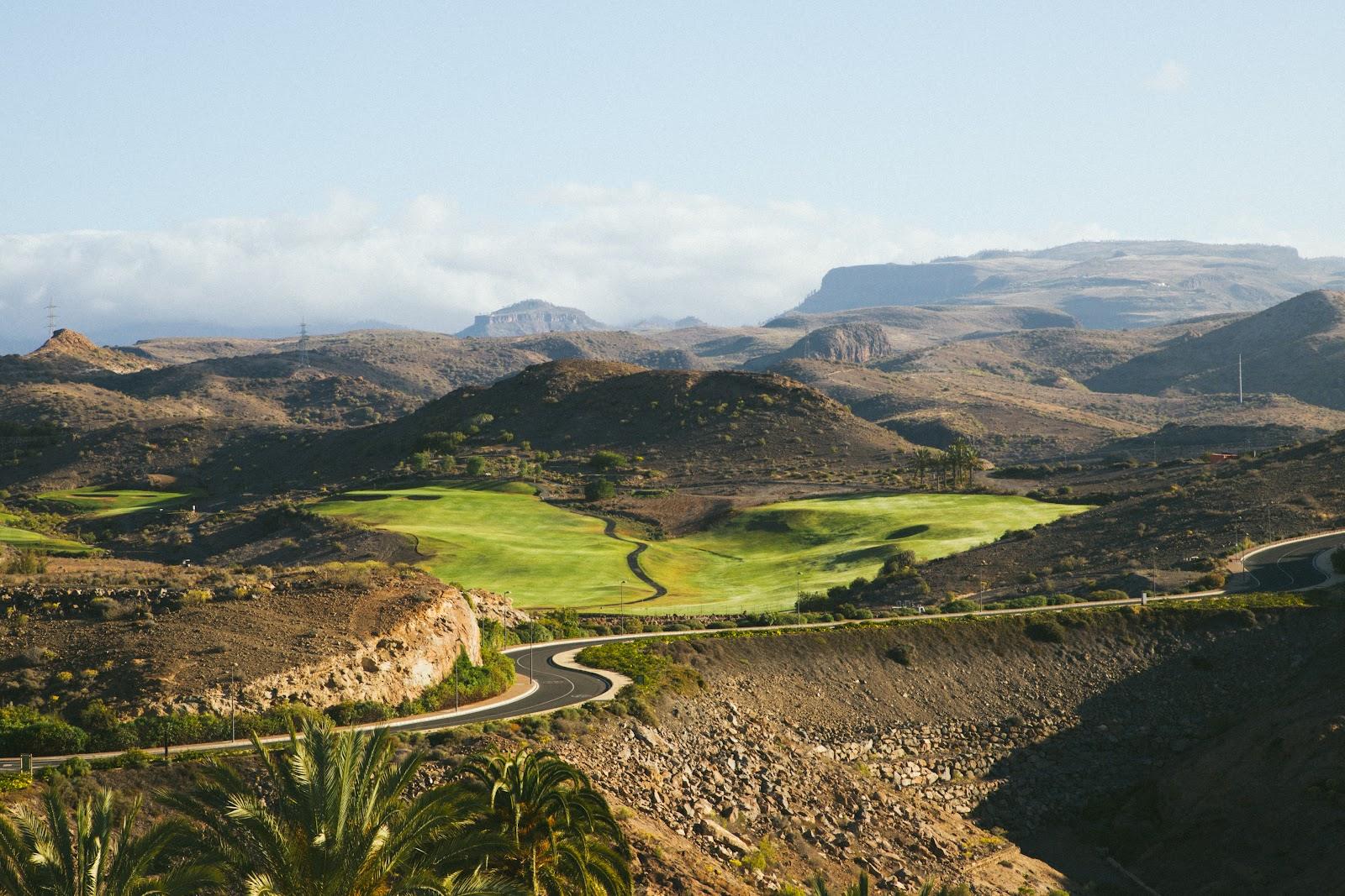 Salobre Golf Old Course, palm lined fairway through lava outcrops above Maspalomas, Gran Canaria, Spain
