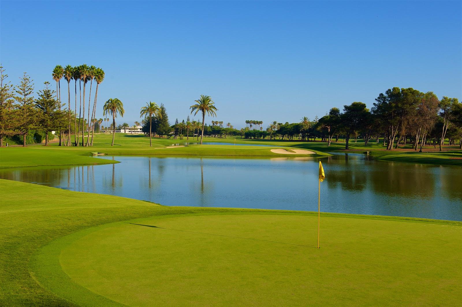 Real Club de Golf Sotogrande, Andalucia, Spain, green and lake framed by palms and white bunkers