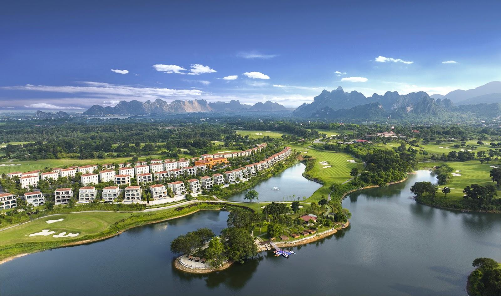 Sky Lake Resort golf course near Hanoi, fairway falling toward Van Son Lake beneath limestone hills, Vietnam
