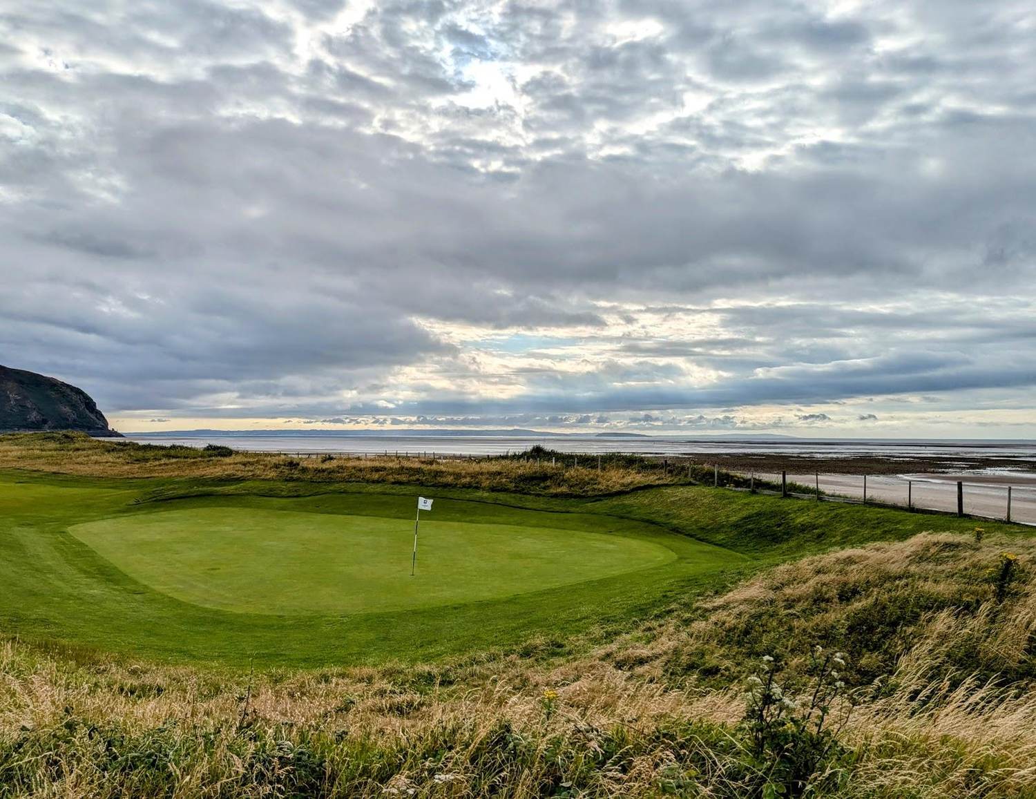 Conwy Caernarvonshire Golf Club, links fairway on the Morfa peninsula with the hills of Snowdonia beyond